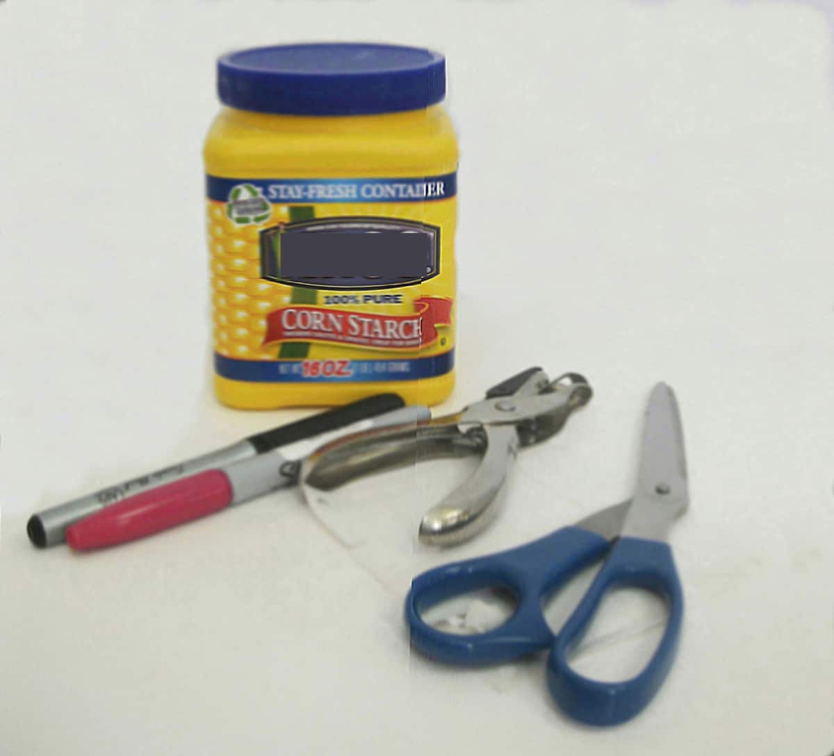 yellow can with blue lid, markers, scissors and hole punch.