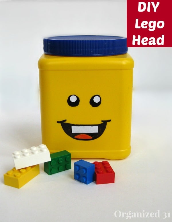 Yellow storage can with blue lid and smiling face with colorful LEGO blocks on white table with title text reading DIY Lego Head