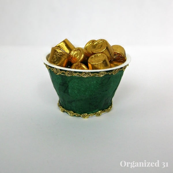 dark green and gold ribbon decorated cup filled with gold foil wrapped candy