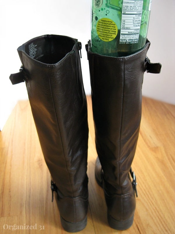 brown boots with green bottle sliding into top of one boot