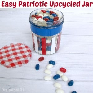 jar decorated with red, white, and blue stripes and candy on white wood table