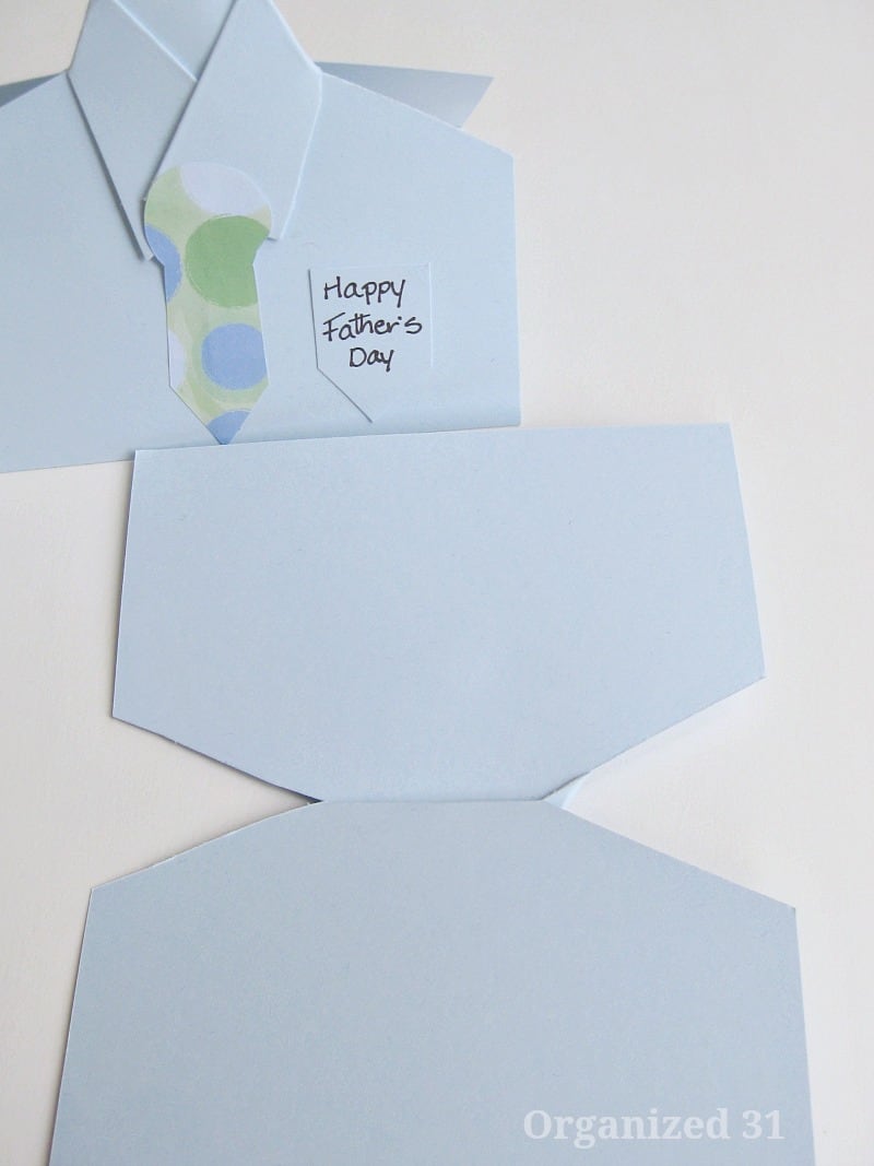 two blue cards shaped like dress shirts with one unfolded flat.