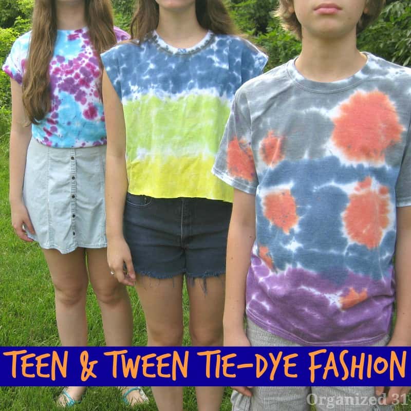 three children wearing tie-dyed shirts in a row