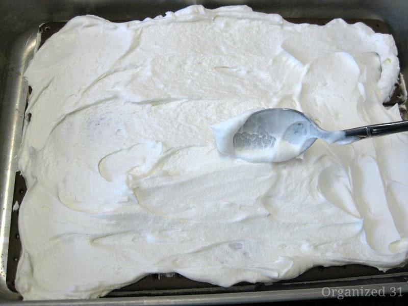 spoon spreading whipped cream in pan
