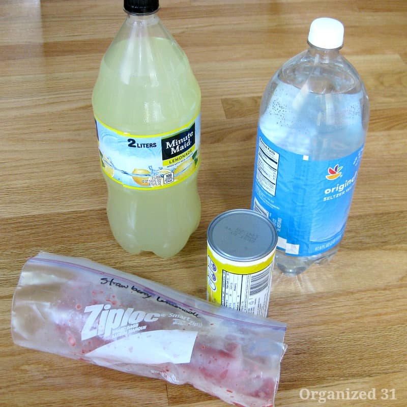 2-liter bottles of lemonade and seltzer water, can of frozen lemonade, and Ziploc of frozen strawberries.
