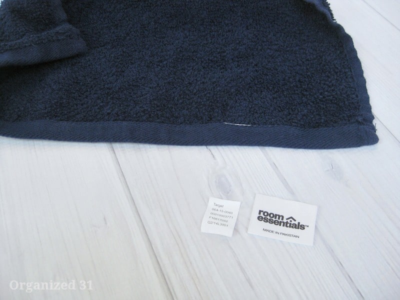 close up of navy blue towel with two cut off tags laying next to it.