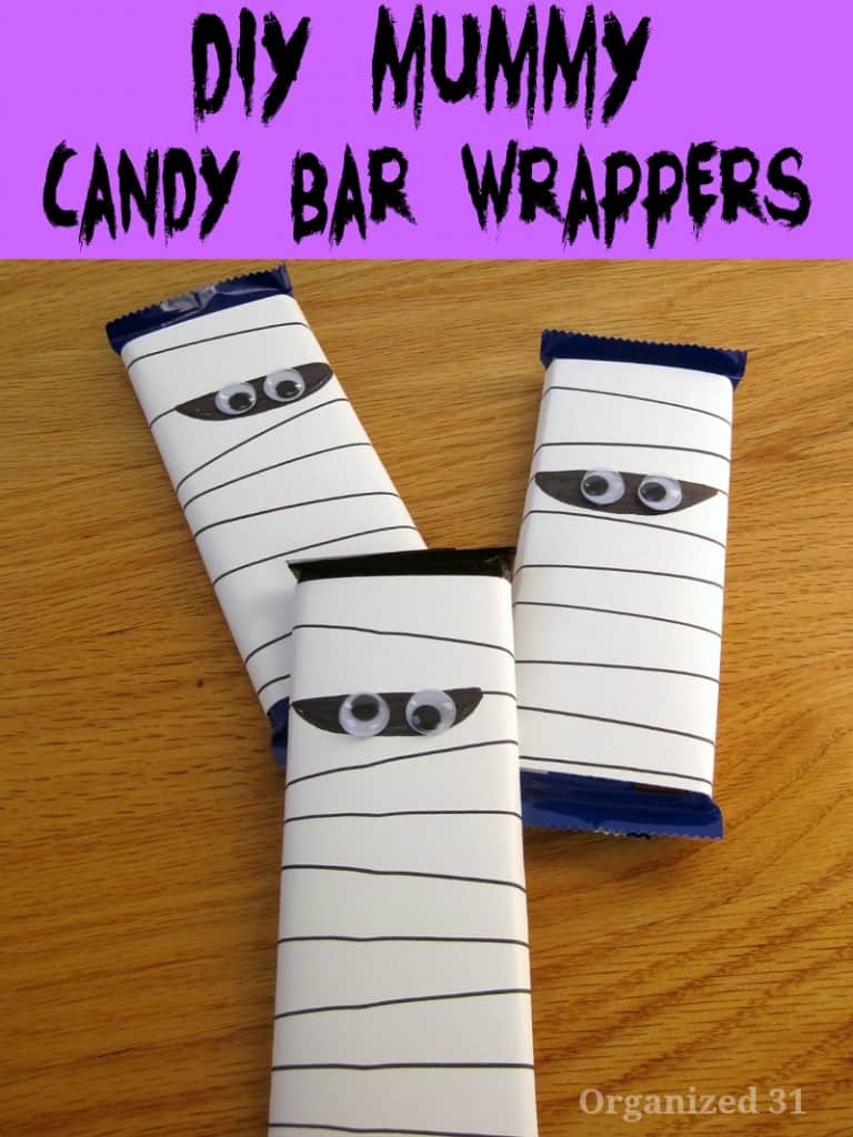 3 mummy wrappers on candy bars on wood table
