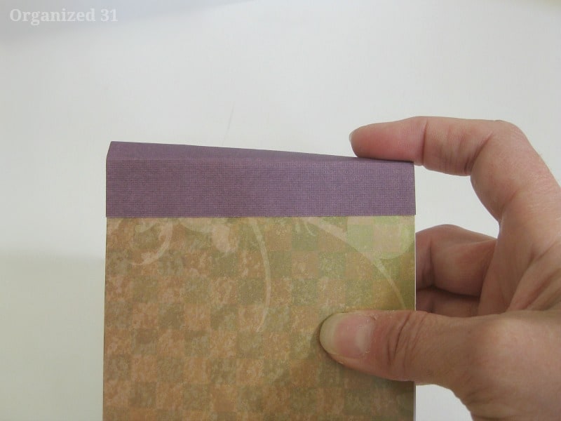 hand holding pad of paper and bending down top binding