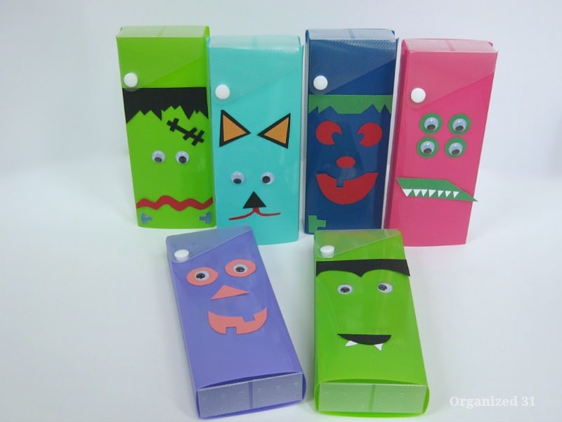 close up of 6 pencil boxes decorated to look like monsters with googly eyes