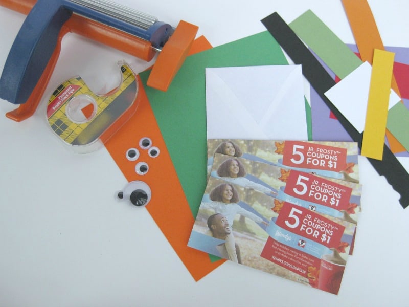 pile of  Frosty coupons, brightly colored paper, googly eyes, tape and paper crimper