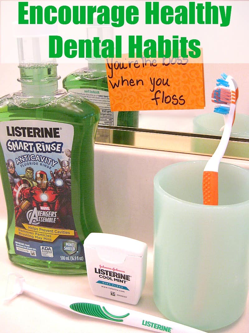 mouthwash, toothbrush and dental floss in front of mirror with sticky note saying "you're the boss when you floss"