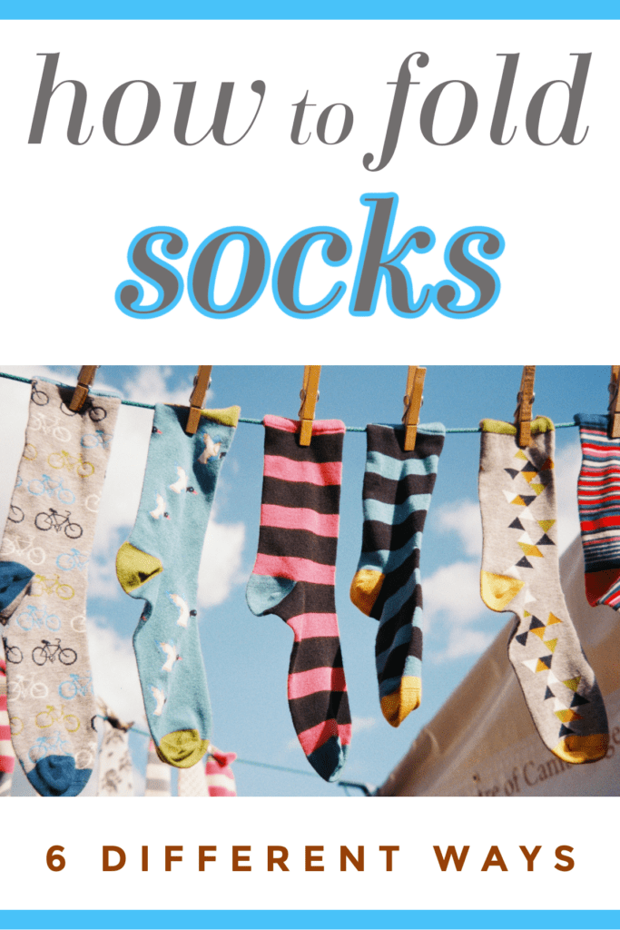 6 different colorful socks hanging on laundry line with clothespins.