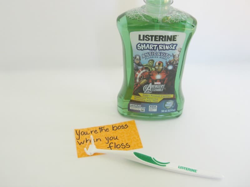 bottle of mouthwash and flossing tool with orange note saying "you're the boss when you floss"