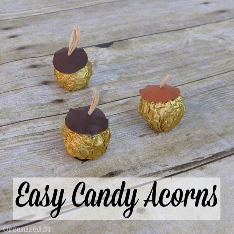3 gold candies decorated to look like acorns on wood table