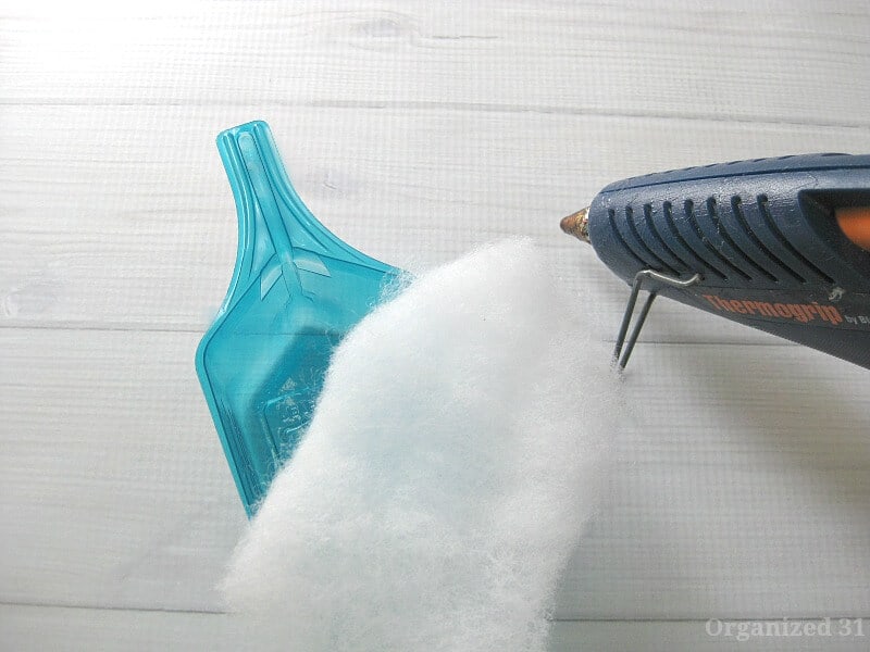 blue plastic laundry scoop, white quilt batting and blue glue gun