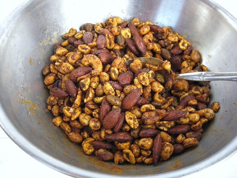 mixing bowl of spiced nuts with spoon