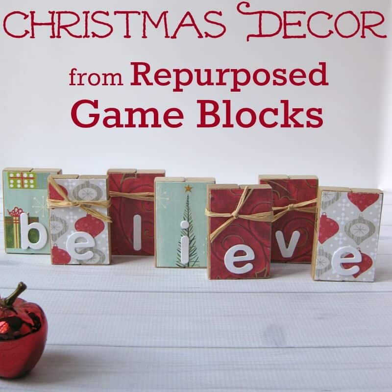 wooden Jenga blocks decorated with Christmas patterned paper and spelling out the word believe.