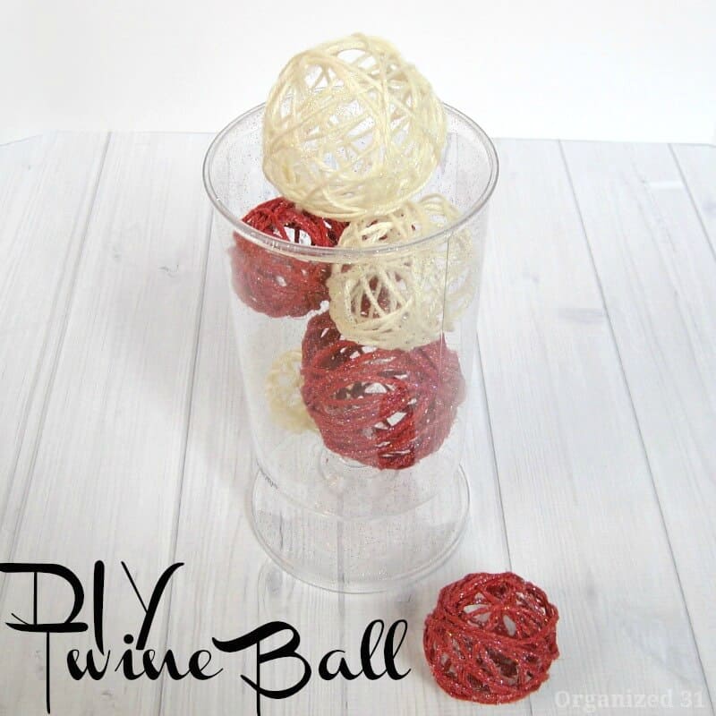 clear vase holding red and white twine balls.