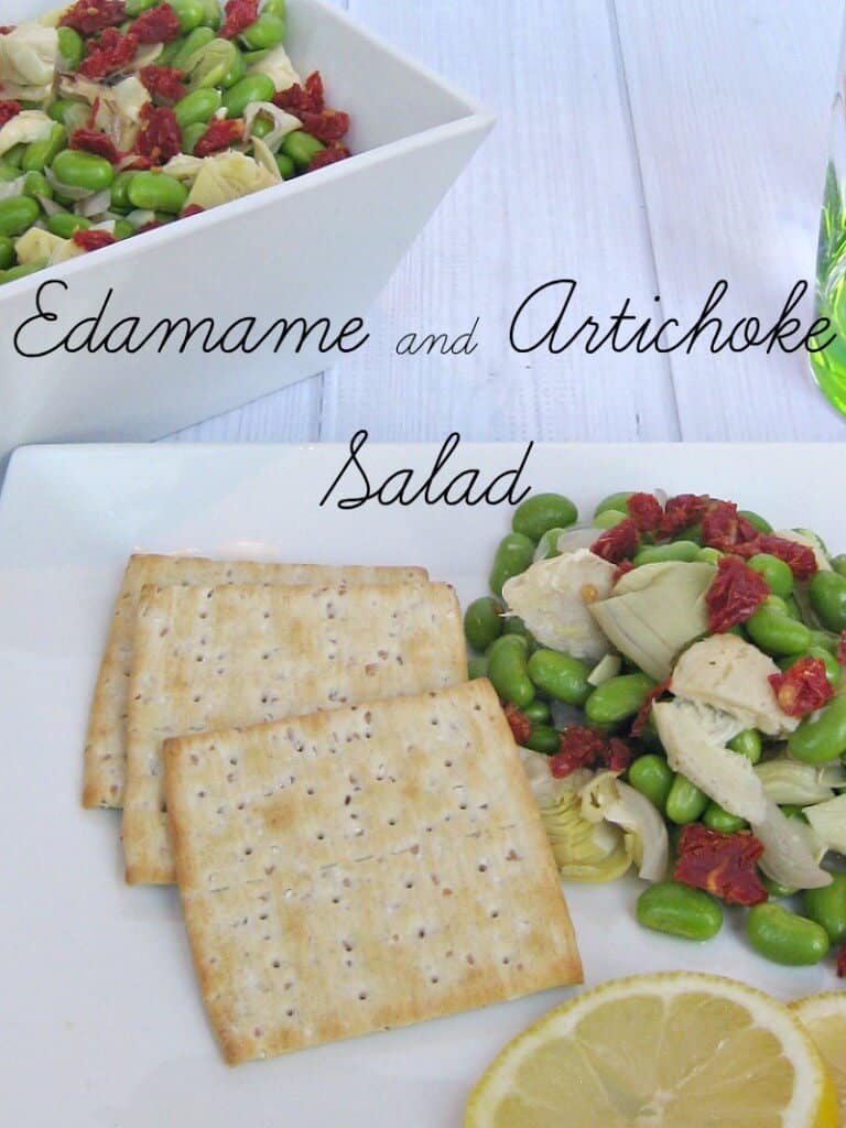 square crackers on a plate with sliced lemons and colorful bean salad.