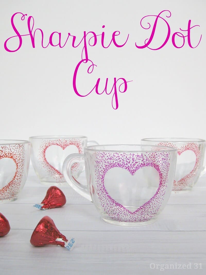 red candy and clear cups with dot hearts on white wood table