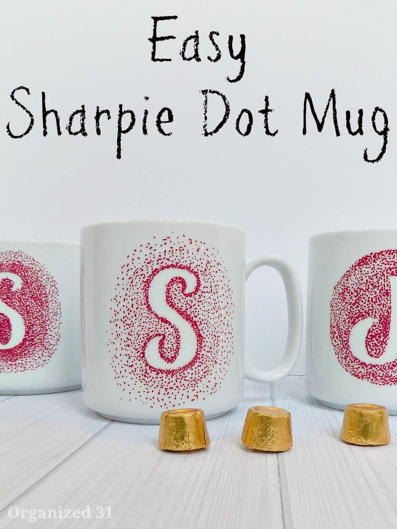 2 white coffee mugs with red monograms made by dots