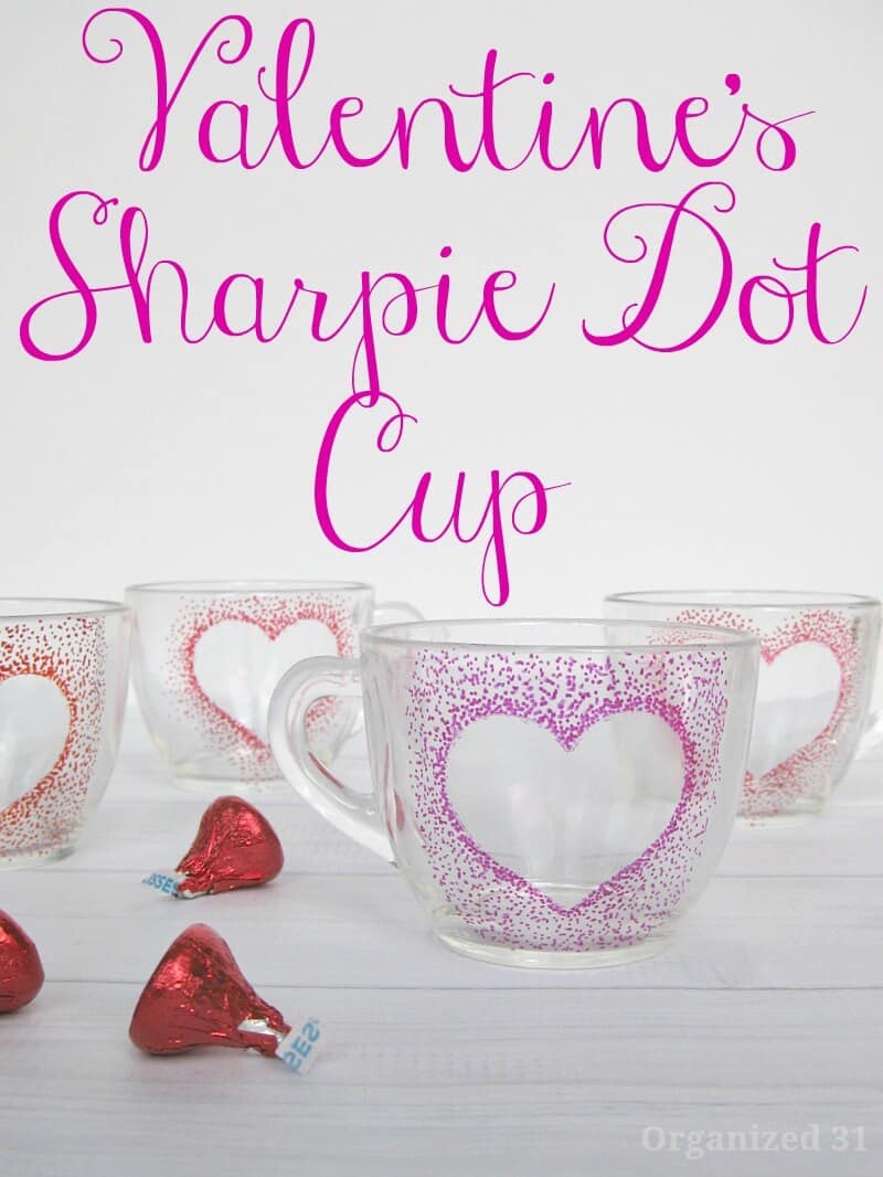 4 clear cups with dot outlined heart and candy on white wood table
