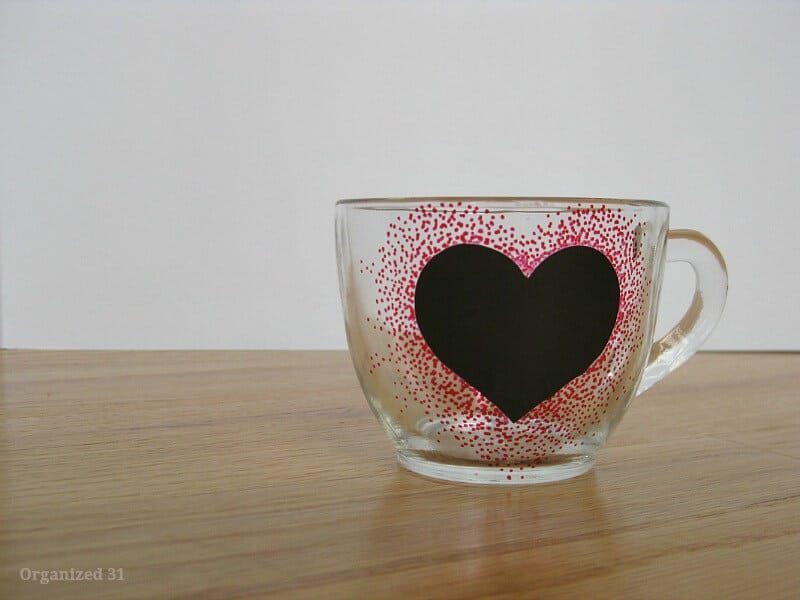 black heart sticker on clear cup with red dots around the heart