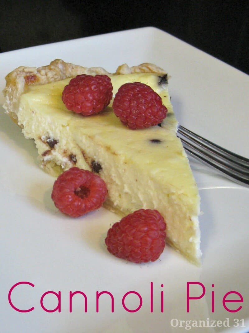 close up of slice of custard pie with raspberries on white plate with fork