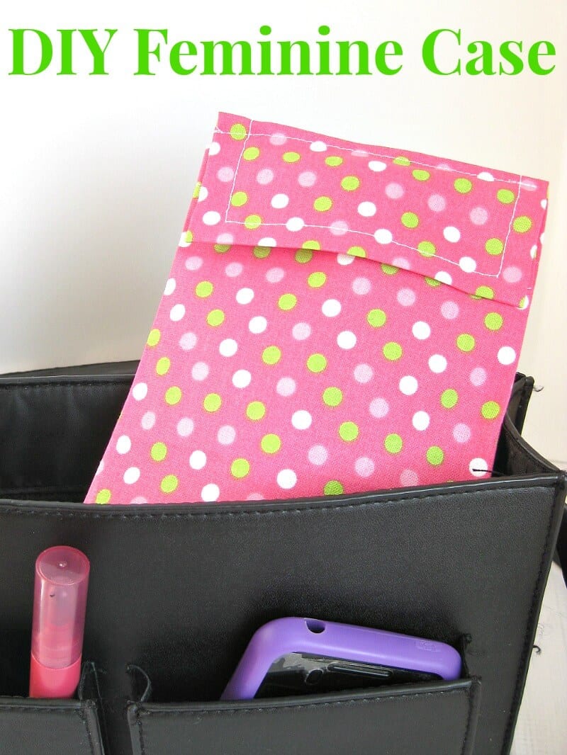 pink fabric with green and white polka dots pouch holding tampons in black purse