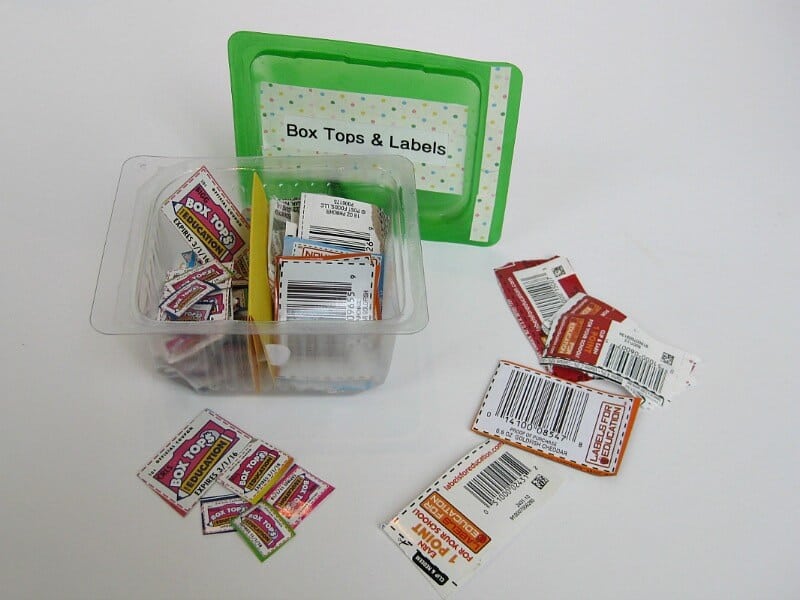 cut out box top coupons organized in plastic container with green lid
