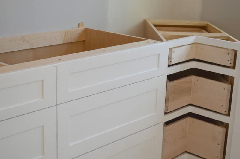white lower kitchen drawers being installed with corner unit of drawers without drawer faceplate not yet installed