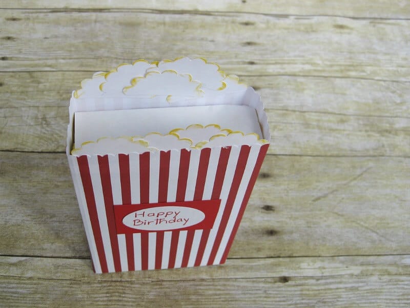 overhead view of crafted movie box of popcorn sleeve for box of candy on wood table