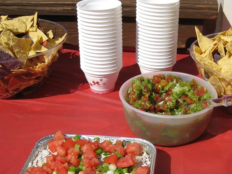 stack of white decorated upcycled containers next to bowl of salsa and chips on red table cloth