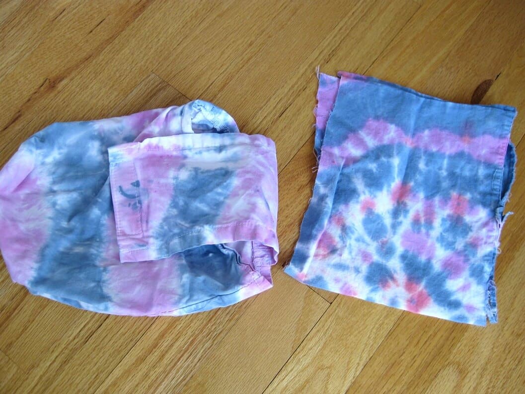 2 pieces of blue, purple and white tie dyed fabric on wood table