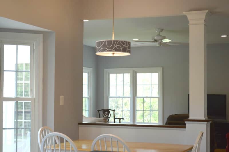 Modern grey and white hanging light over white and light wood dining table