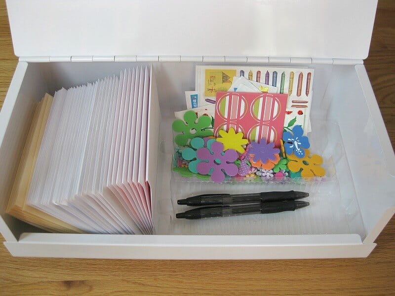 open white box filled with cards, pen and stickers