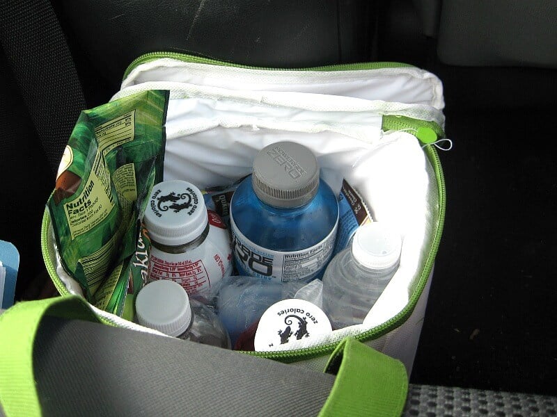 view inside small cooler bag with bottles of water and juice and snack packets