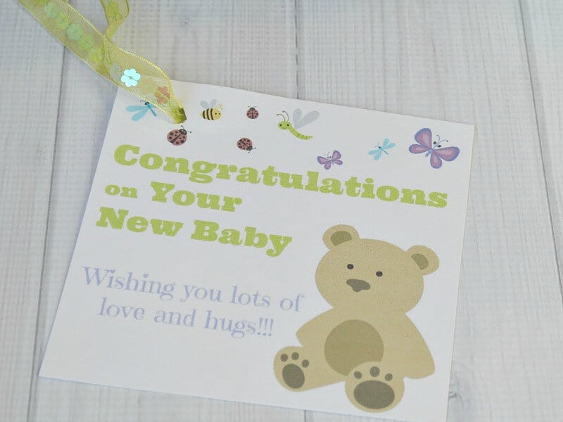 close up of gift tag with teddy bear image and text saying "congratulations on your new baby"