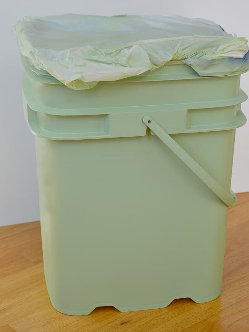 bucket painted green with top covered with plastic bag