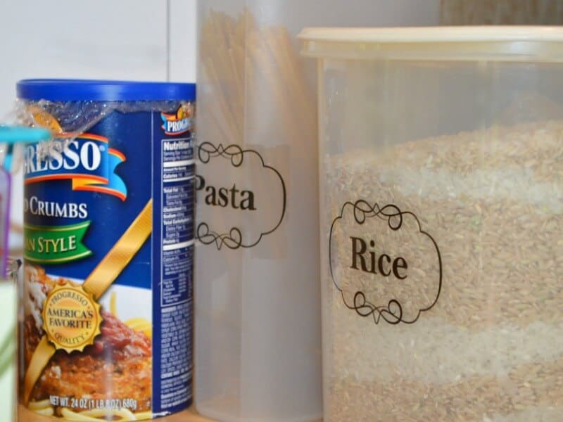2 clear containers labeled "pasta" and "rice" next to blue canister of bread crumbs.
