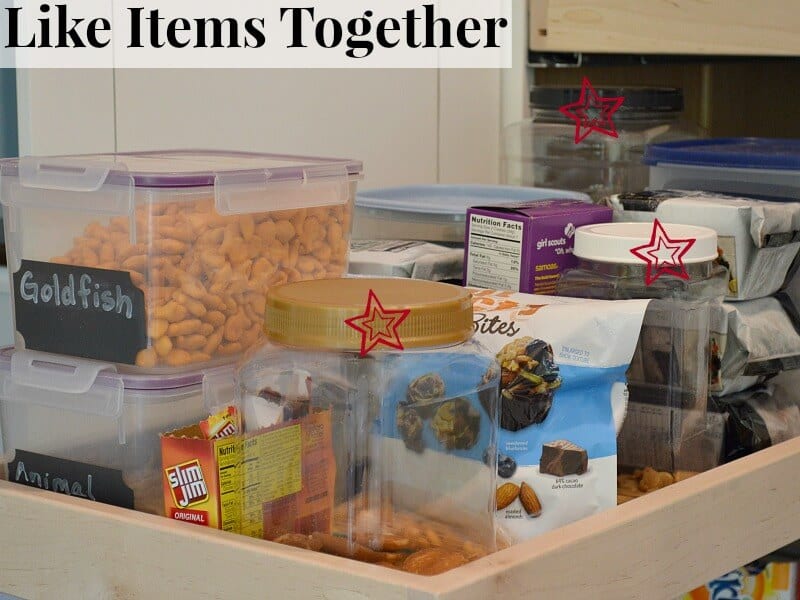 tidy pullout shelf with containers and canisters of food with red overlay stars on the lid of 2 containers