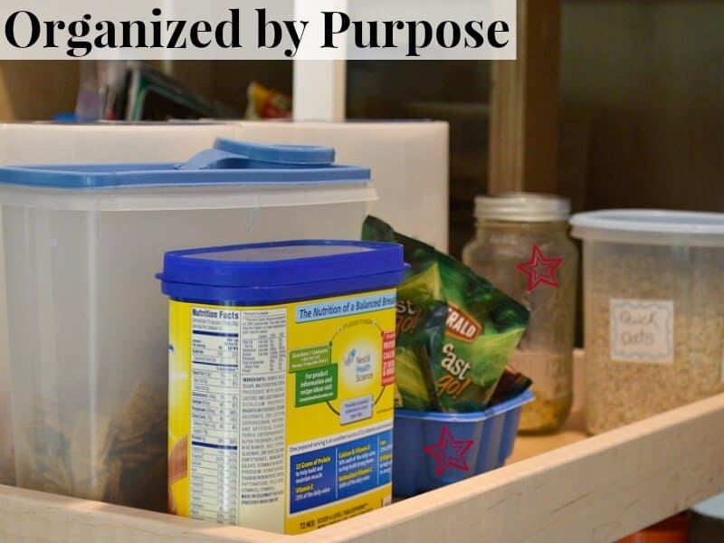pullout shelf with clear containers of cereal, oats and one yellow and blue container