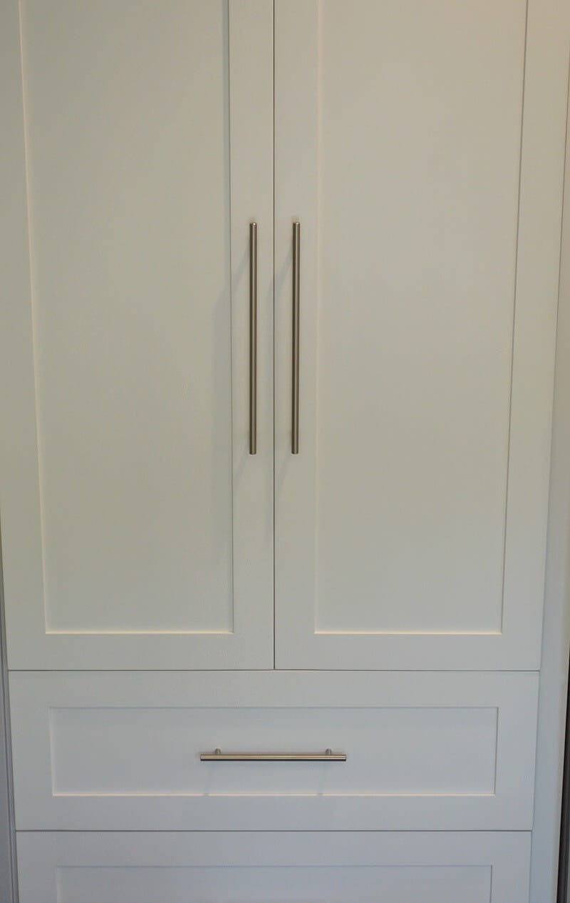 close white wood cabinet doors with chrome bar handles.