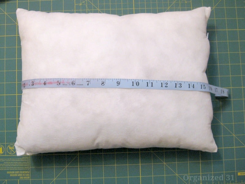 white pillow form with blue measuring tape laying on top of it