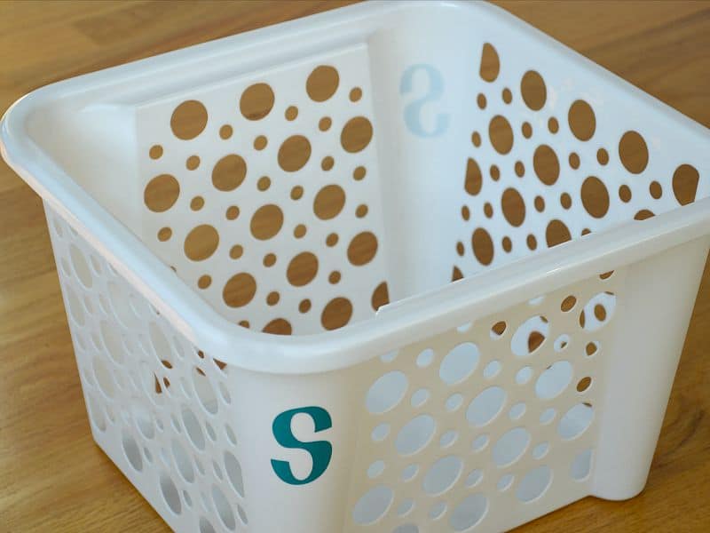 overhead view of a white plastic bin with a blue letter S on one corner
