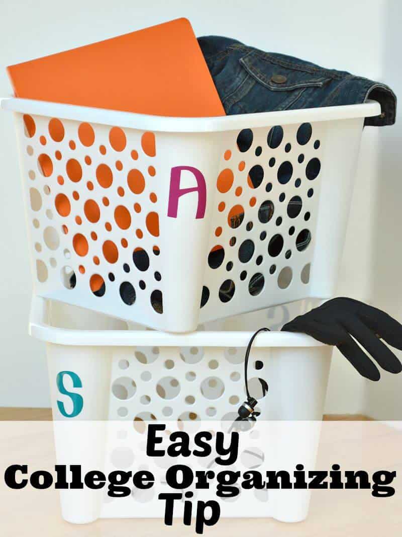 white bin with purple letter A holding a jean jacket and orange folder stacked on top of white bin with blue letter S holding black gloves and earbuds