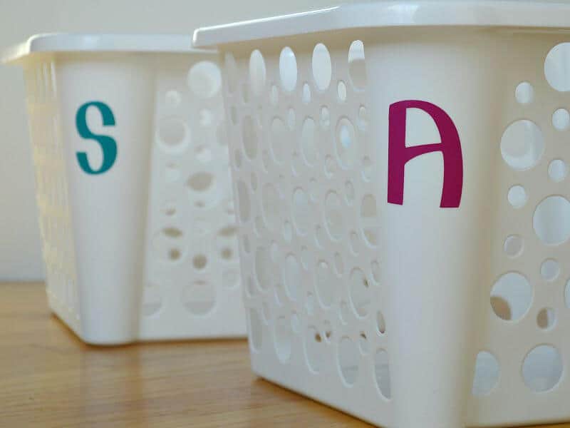 sideview of 2 white plastic bins, one with a blue letter A and one with a purple letter A