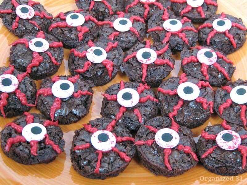 overhead view of round brownies decorated to look like bloodshot eyeballs on wood table