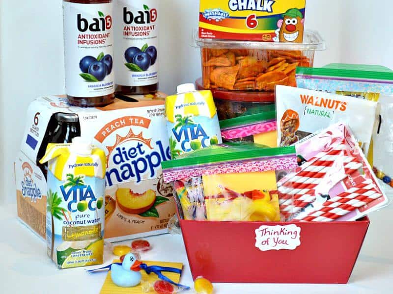 red basket with brightly colored snacks, drink boxes, candy, rubber ducks and chalk