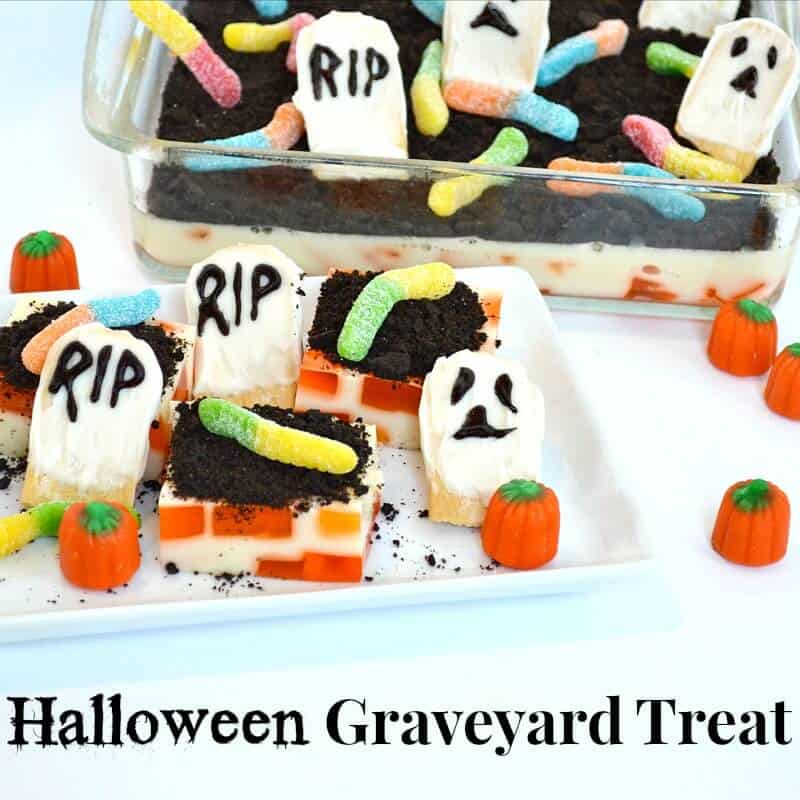 dessert that looks like a graveyard with candy worms, candy pumpkins and cookie ghosts.